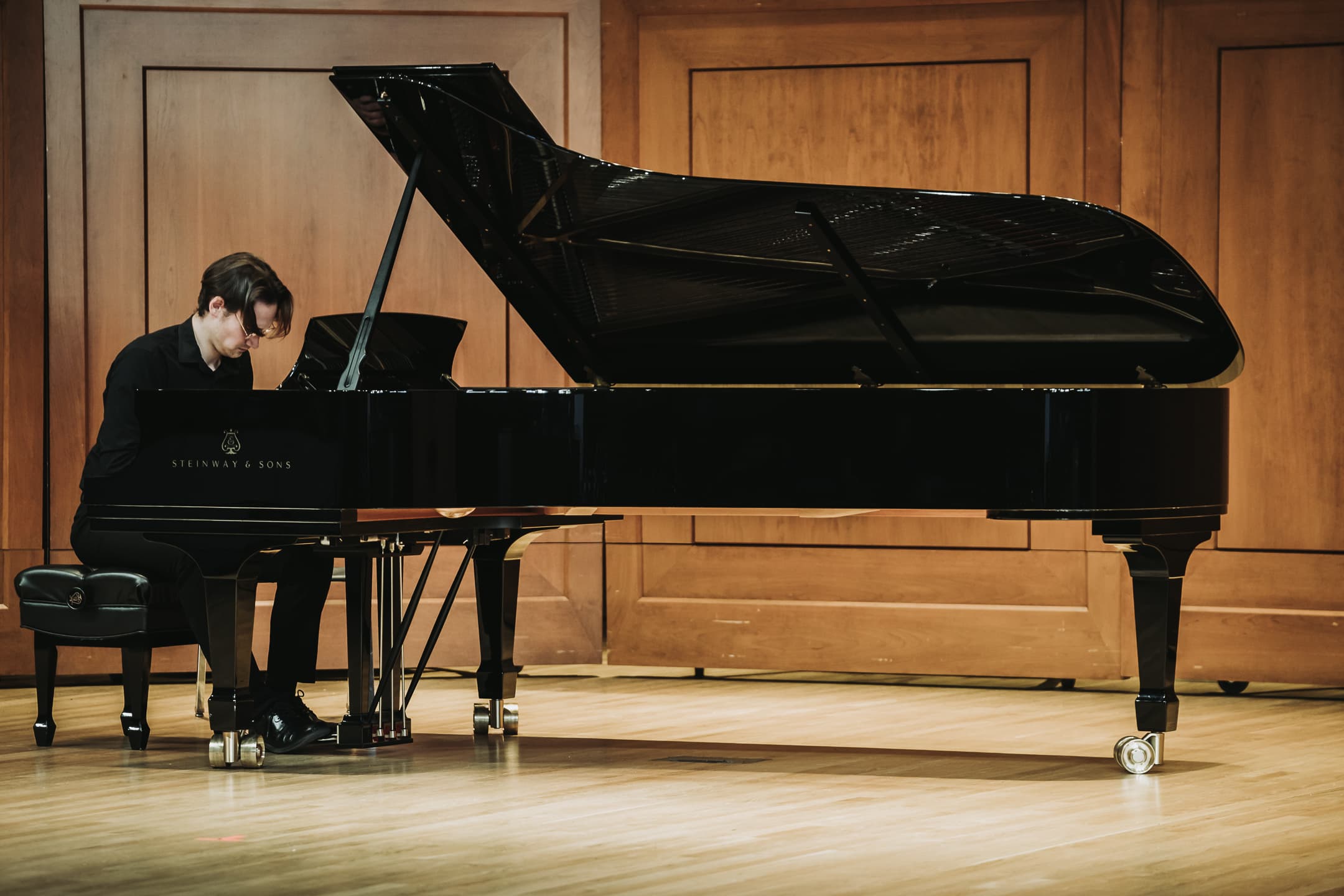Pianist performing at a recital on a grand piano