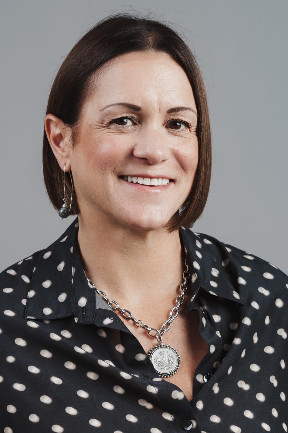 Smiling professional headshot against a gray backdrop
