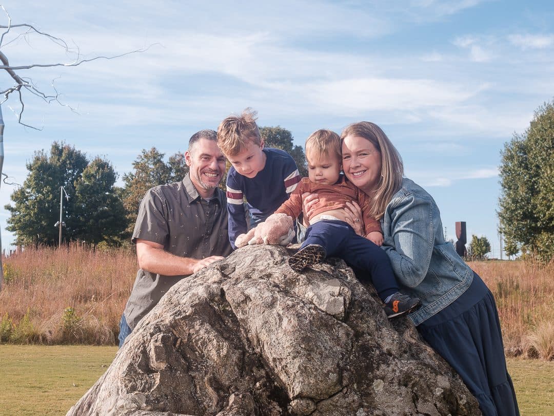 Family gathered around a large rock