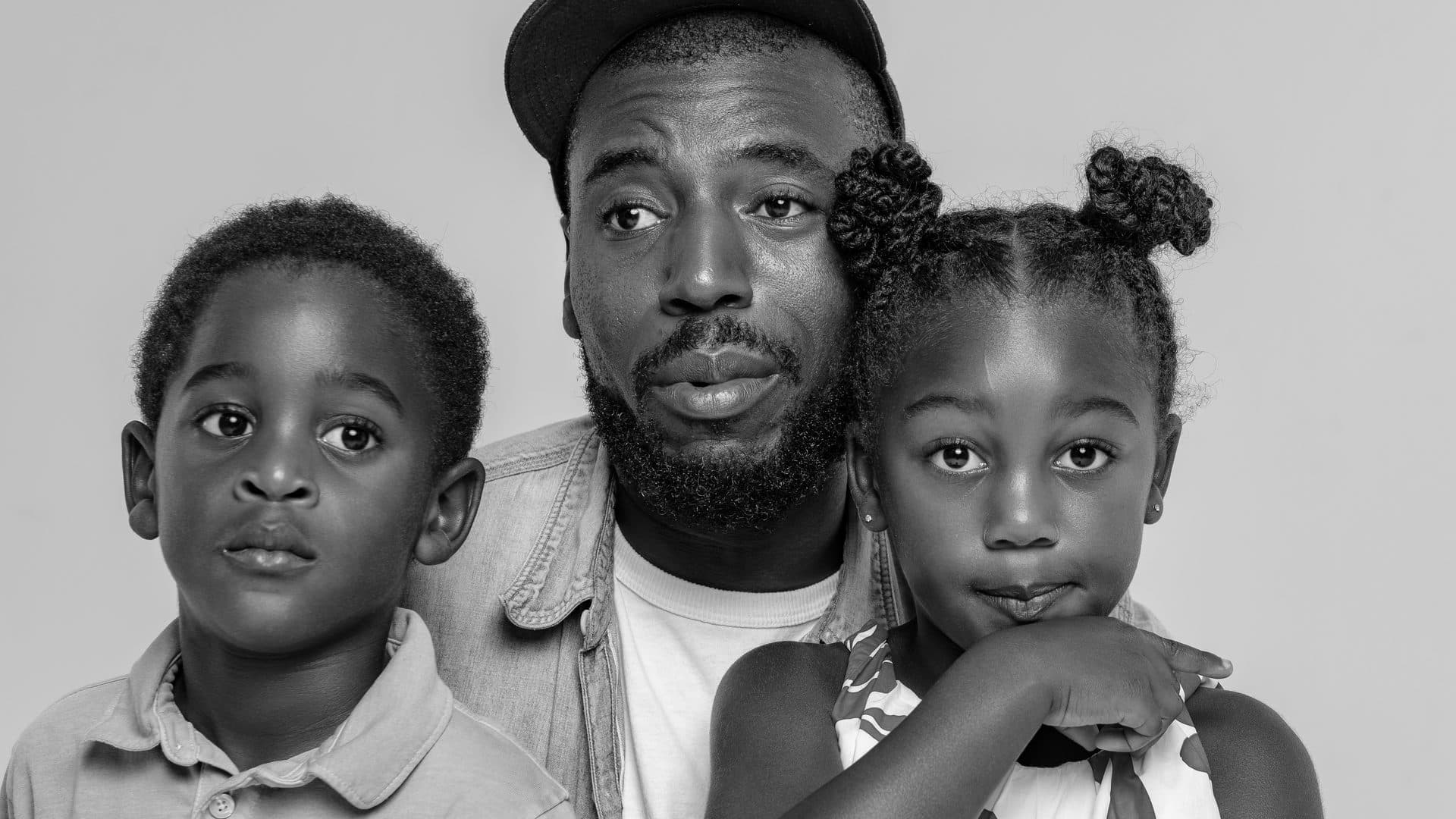 Father with his son and daughter in a black and white studio portrait
