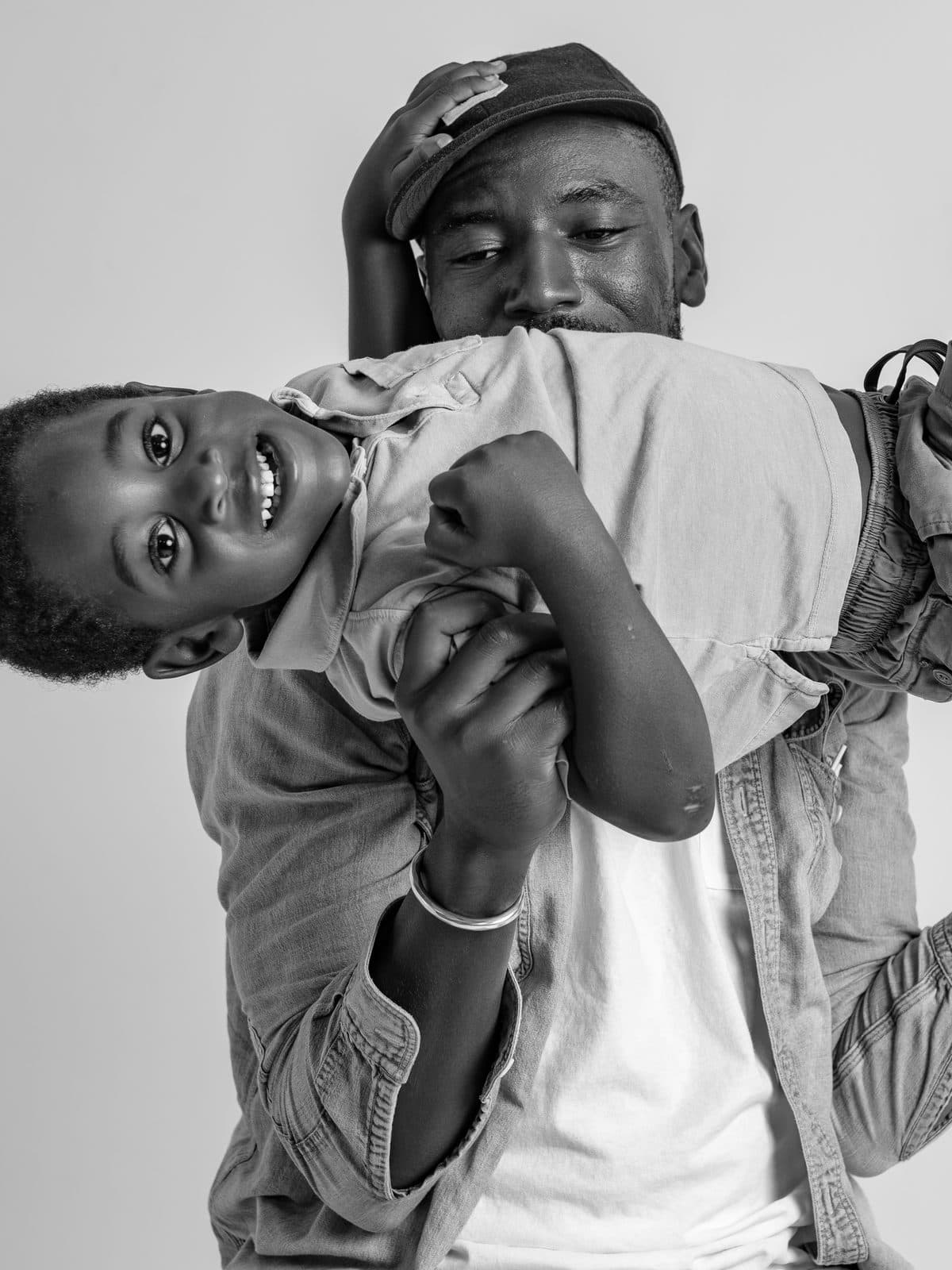 Father holding his son upside down and laughing
