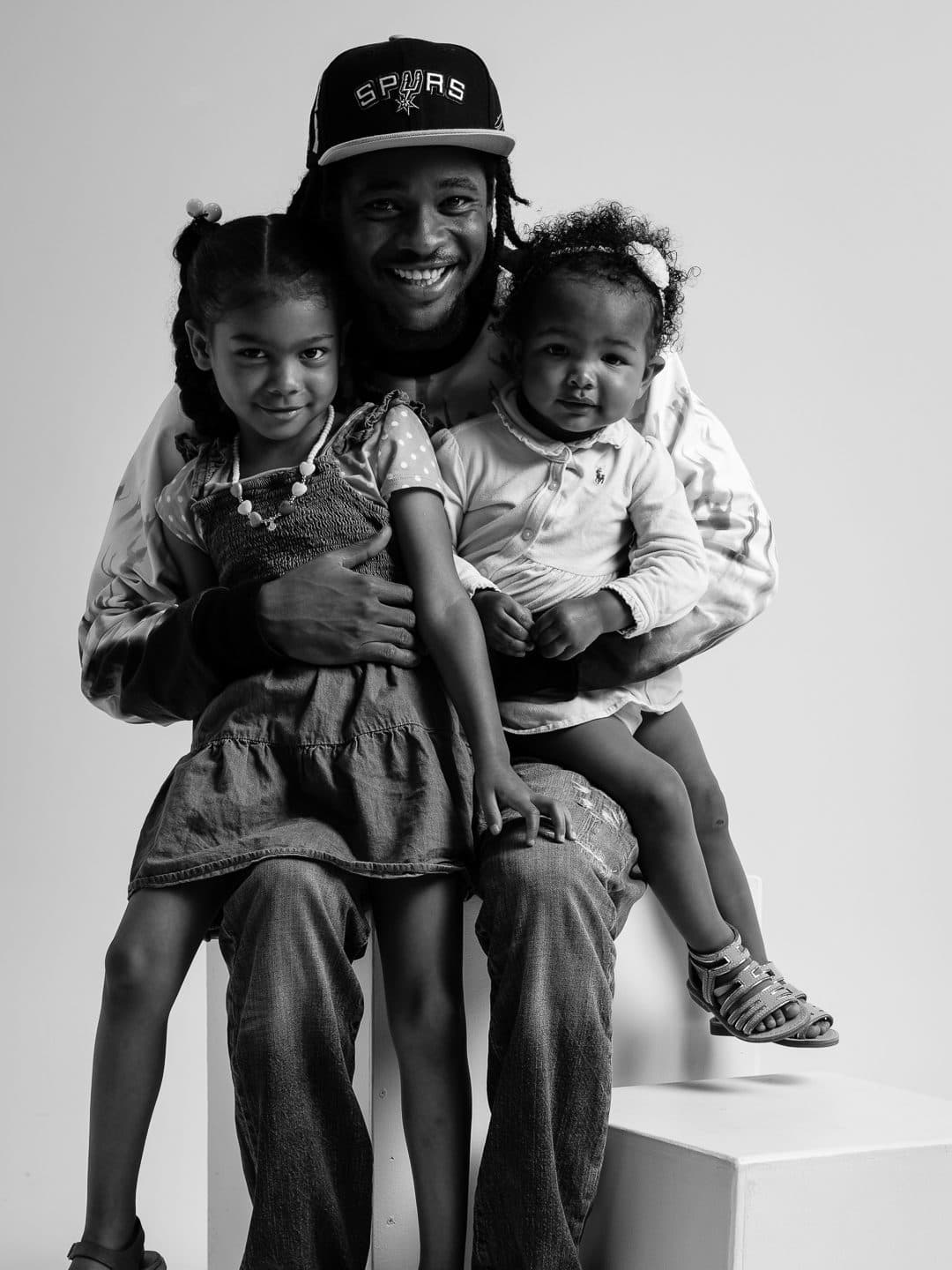 Father seated with his daughters on his lap