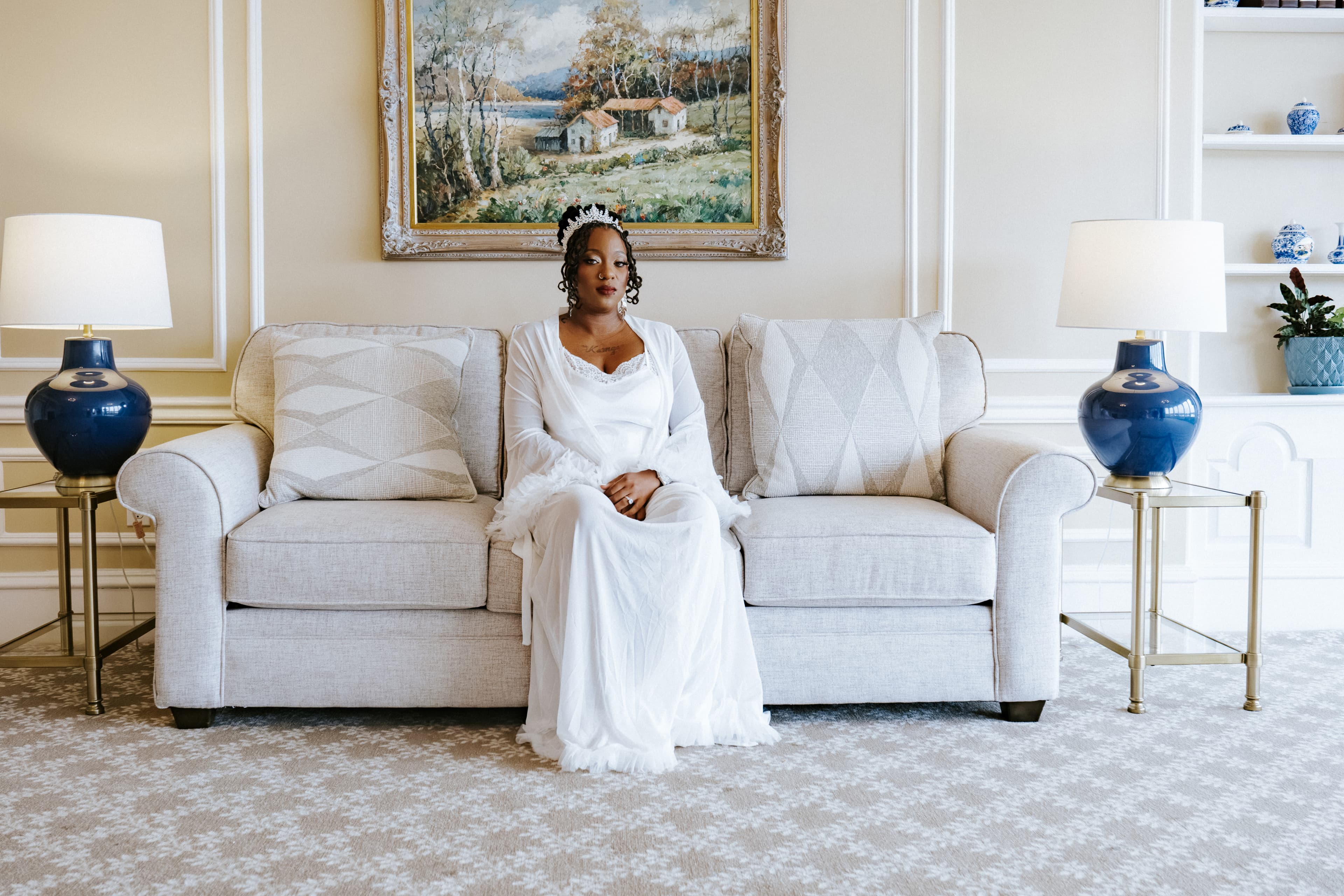 Bride in a white dress seated on a sofa in an elegant room