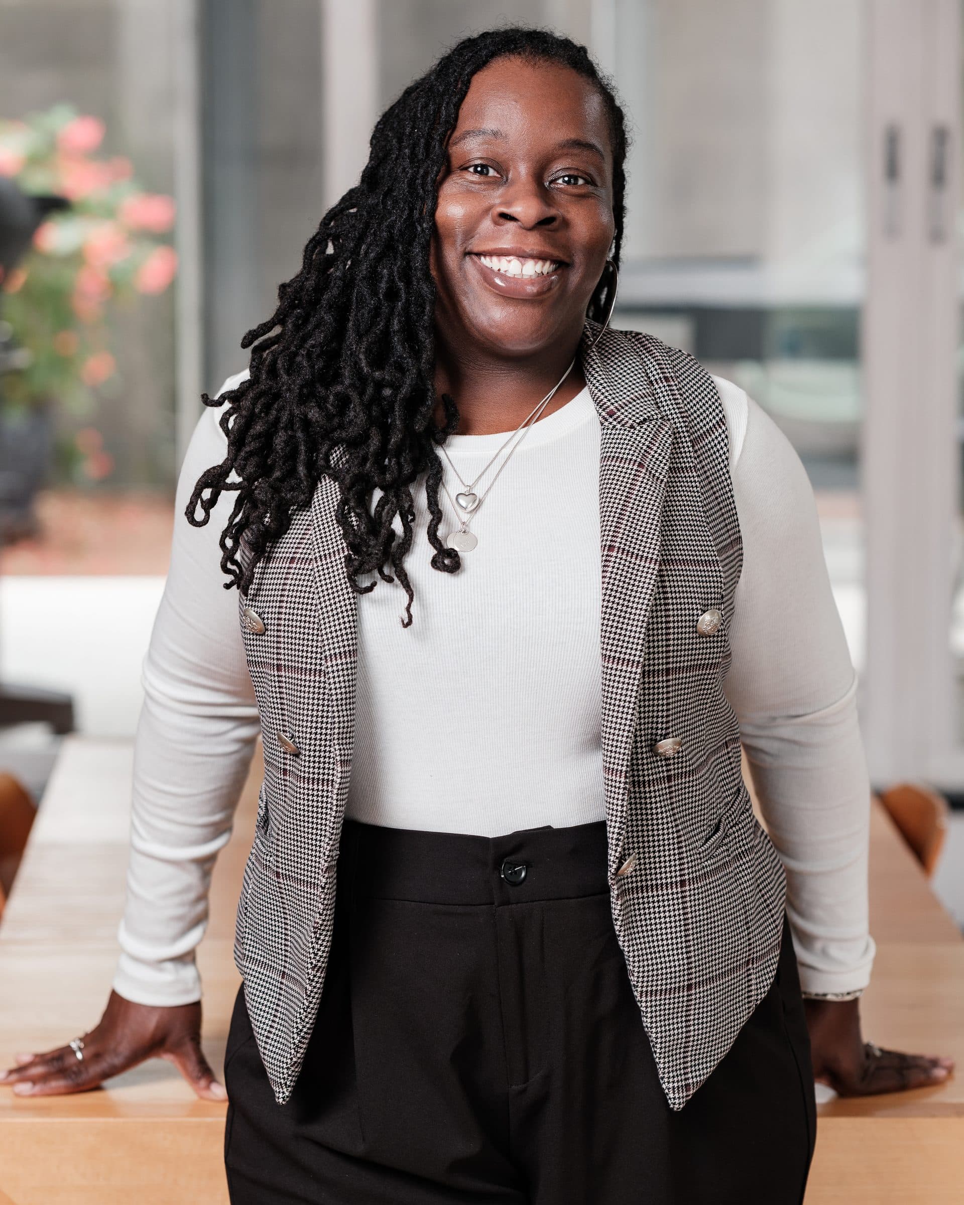Environmental branding portrait: woman smiling in houndstooth blazer