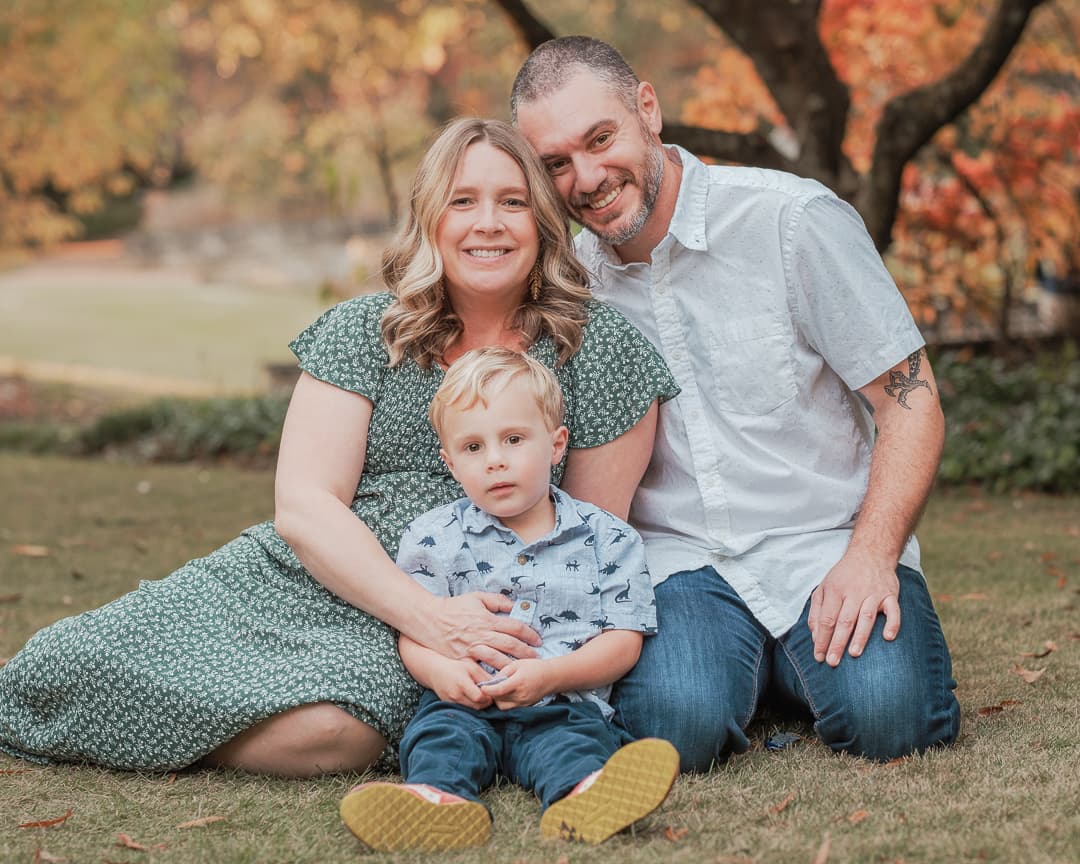 Family portrait of parents and their child outdoors in autumn