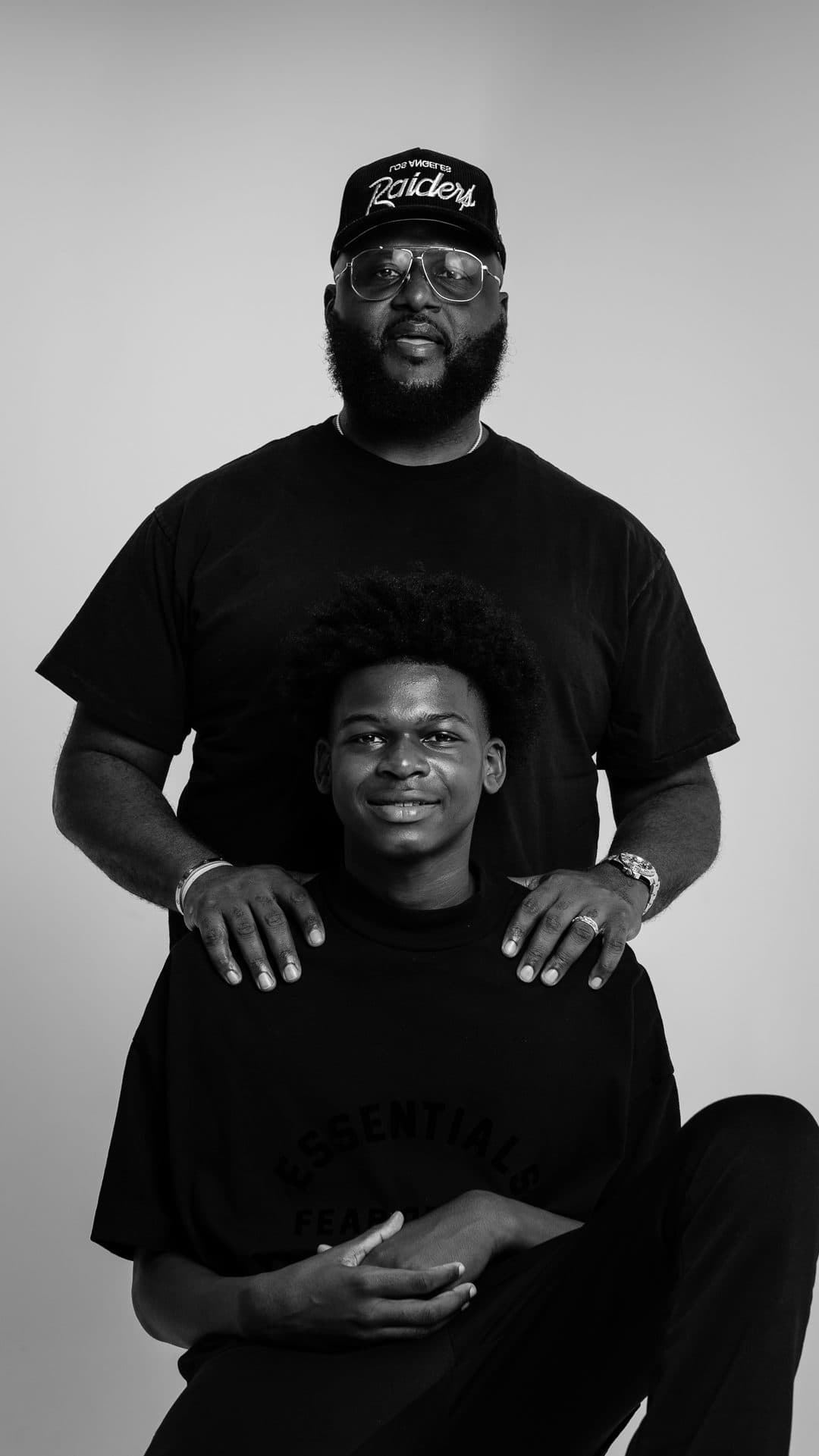 Black father standing behind his son in a portrait session