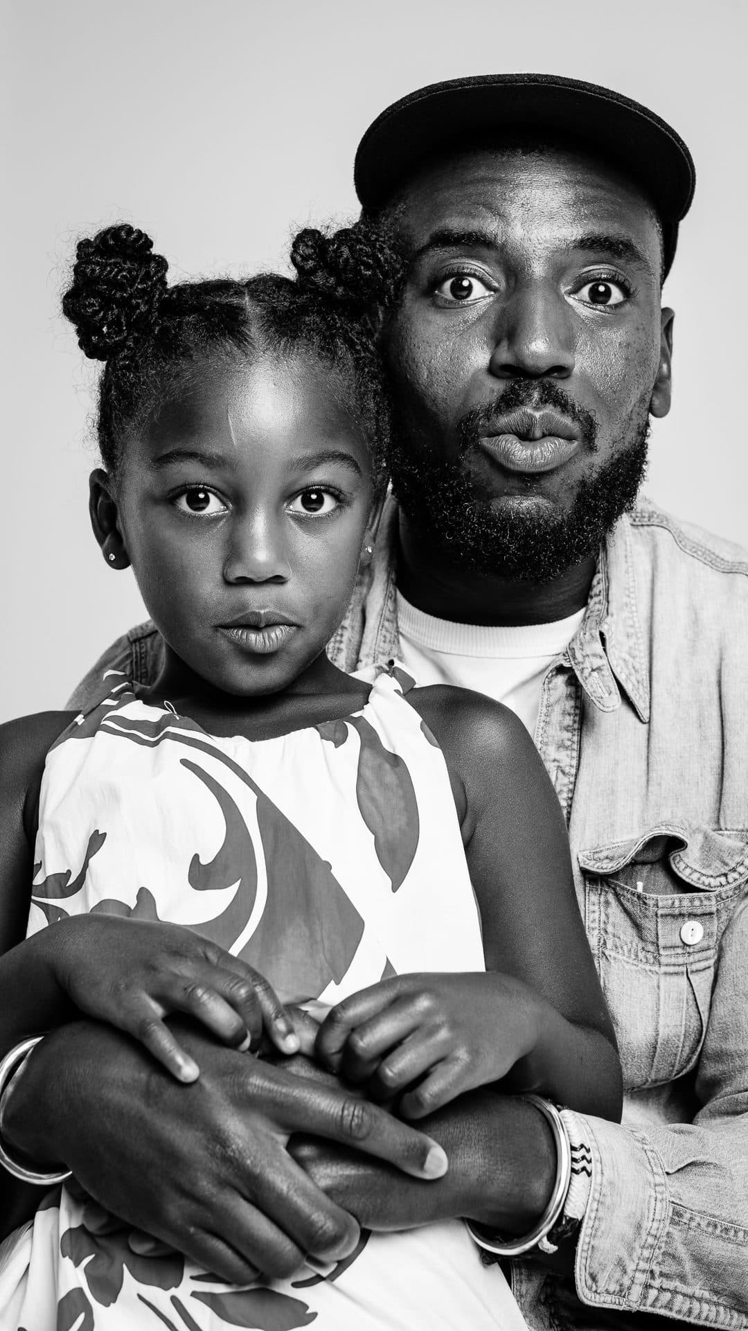Black father holding his daughter during a portrait session