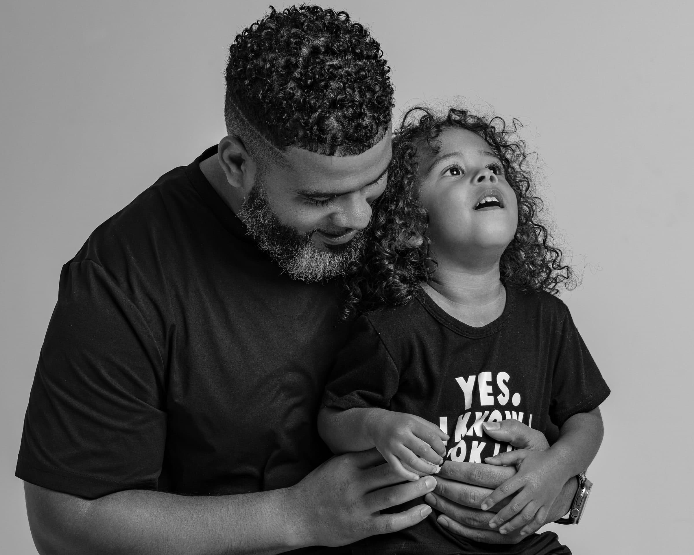 Black father embracing his child during a portrait session