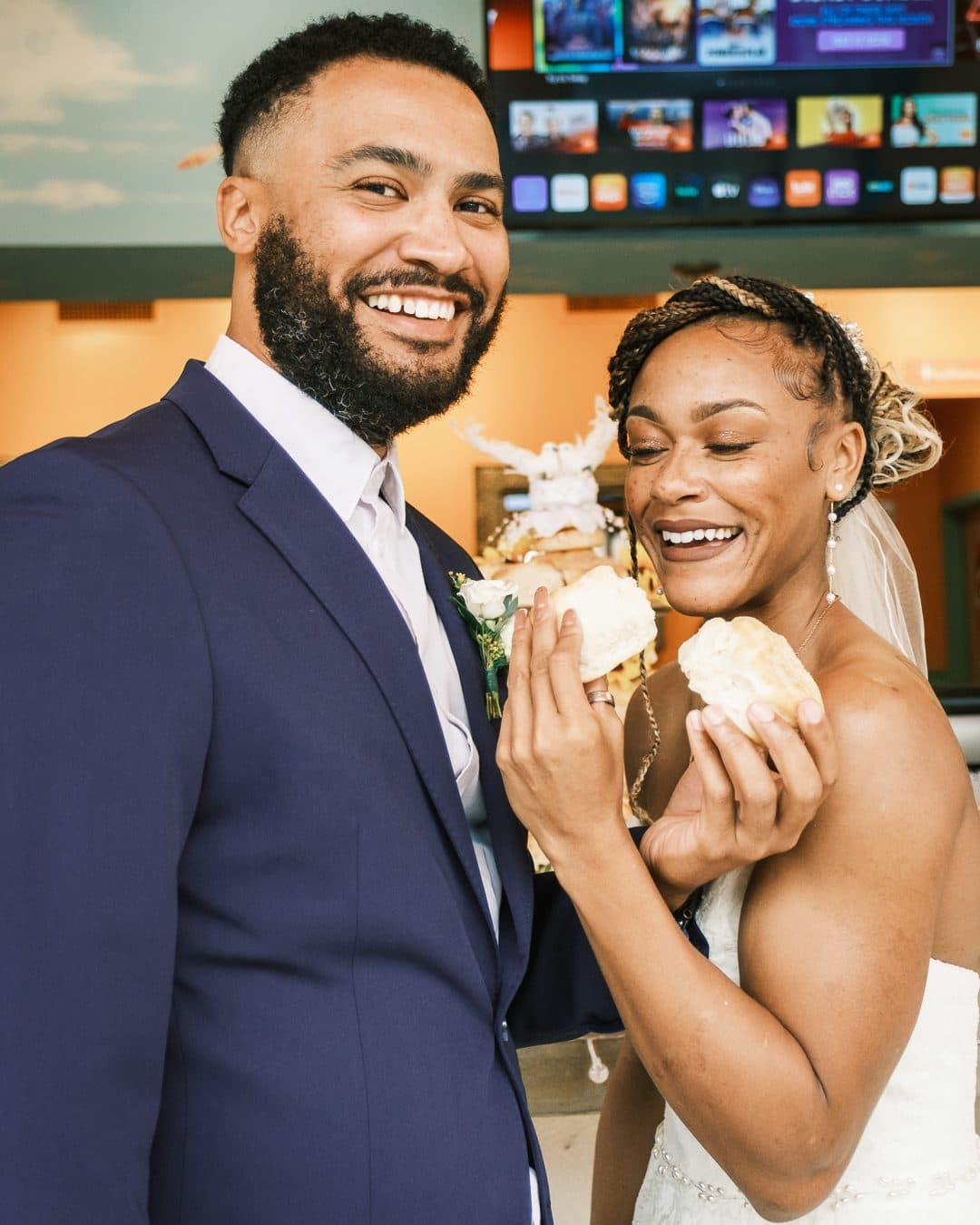 Couple holding biscuits together during their wedding celebration at the Flying Biscuit open house