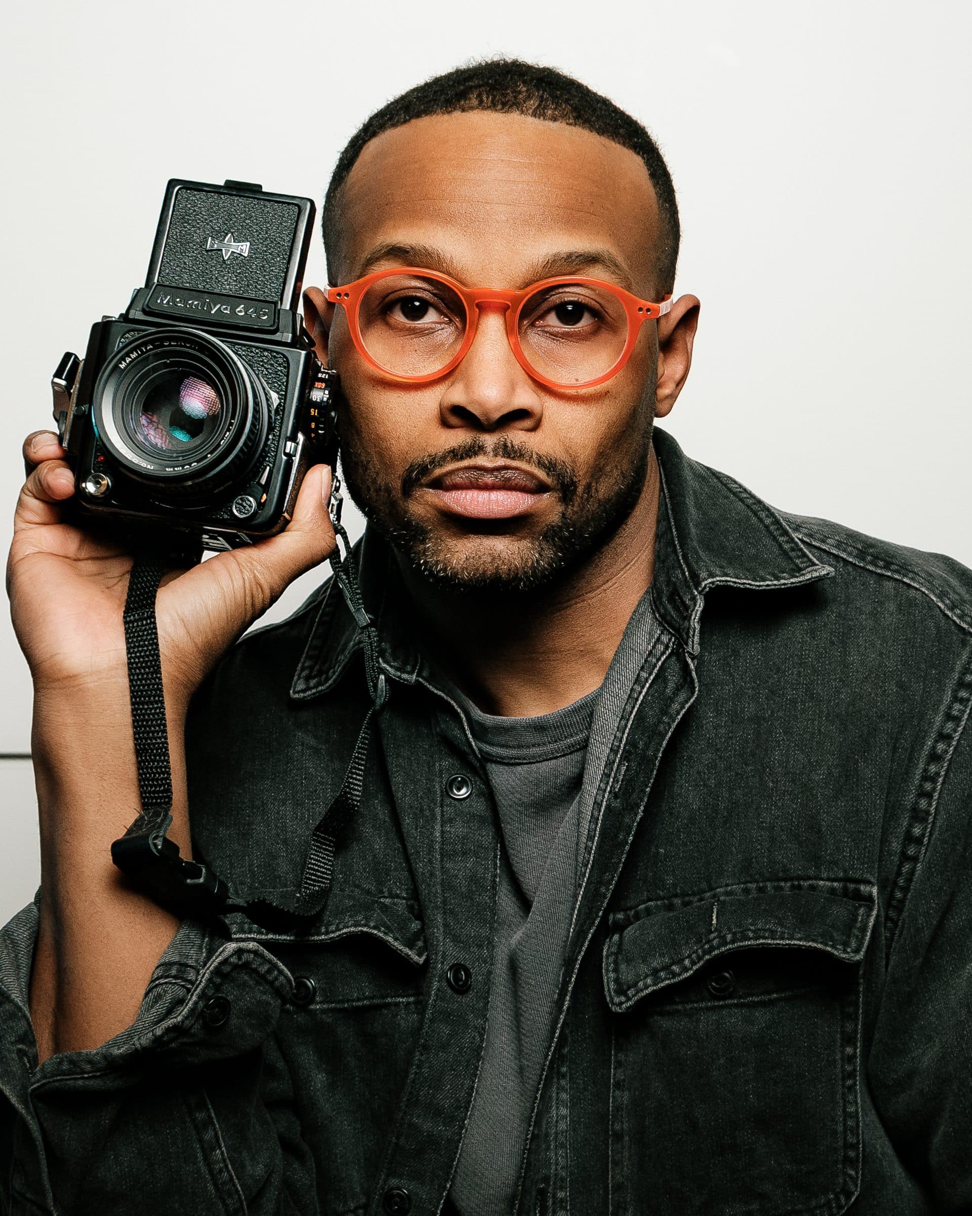 Portrait of photographer John Kornegay holding a vintage camera