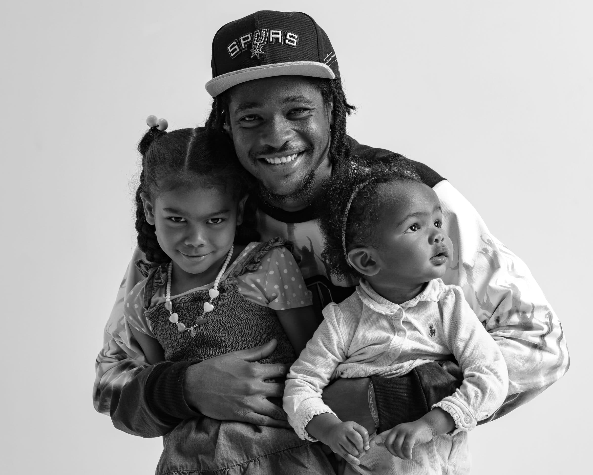 A man holding two young ladies during a family portrait session