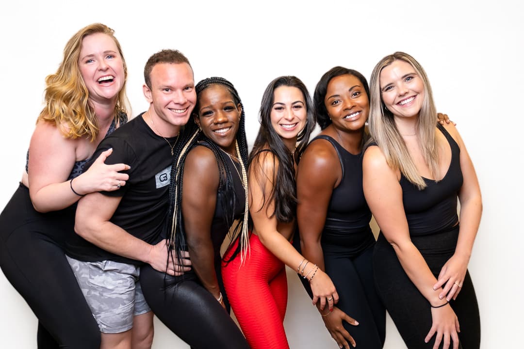 Six people posing together in a studio